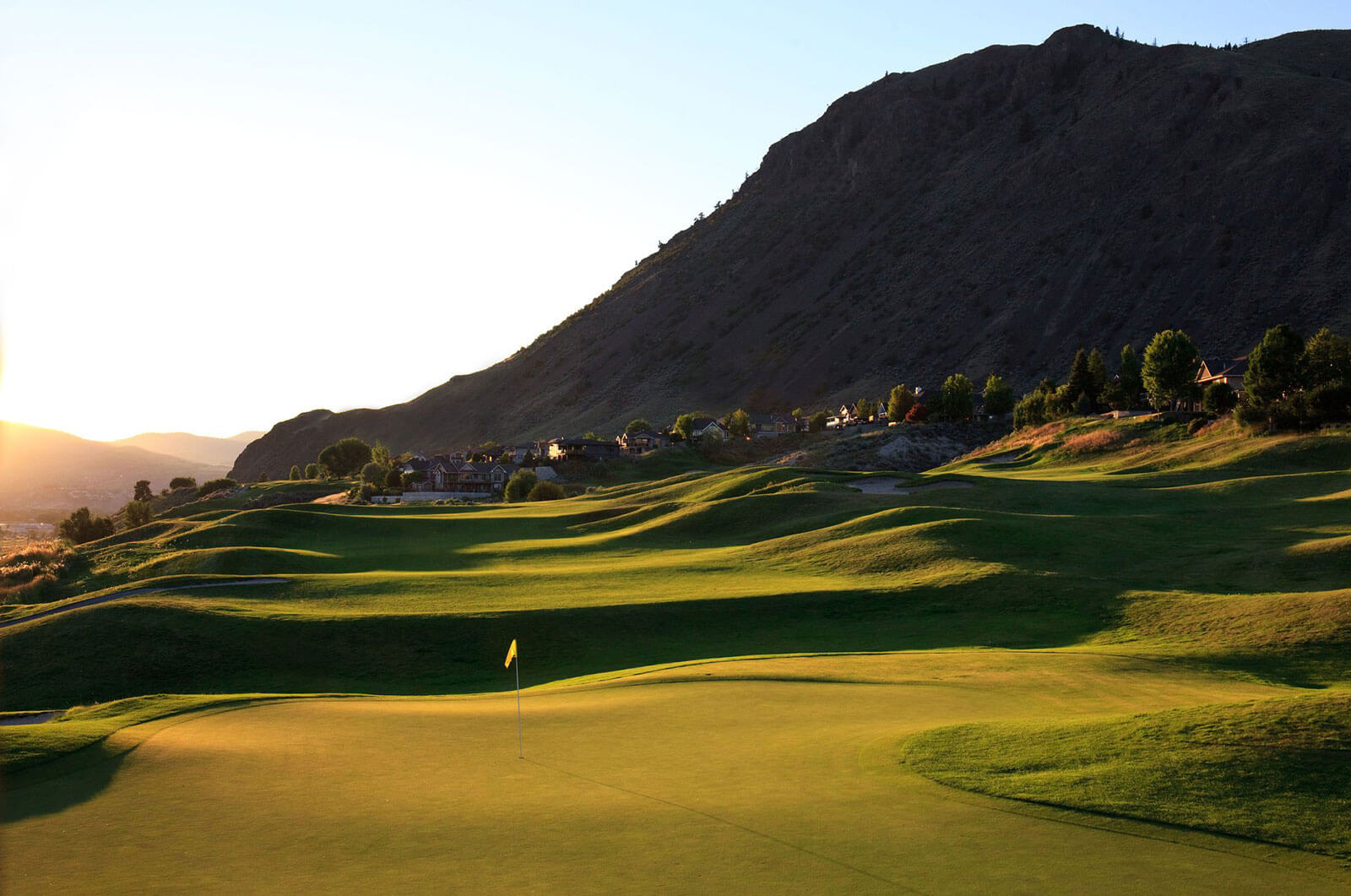 Sunset view of Bighorn Golf Course green with rolling fairways and Kamloops mountain backdrop