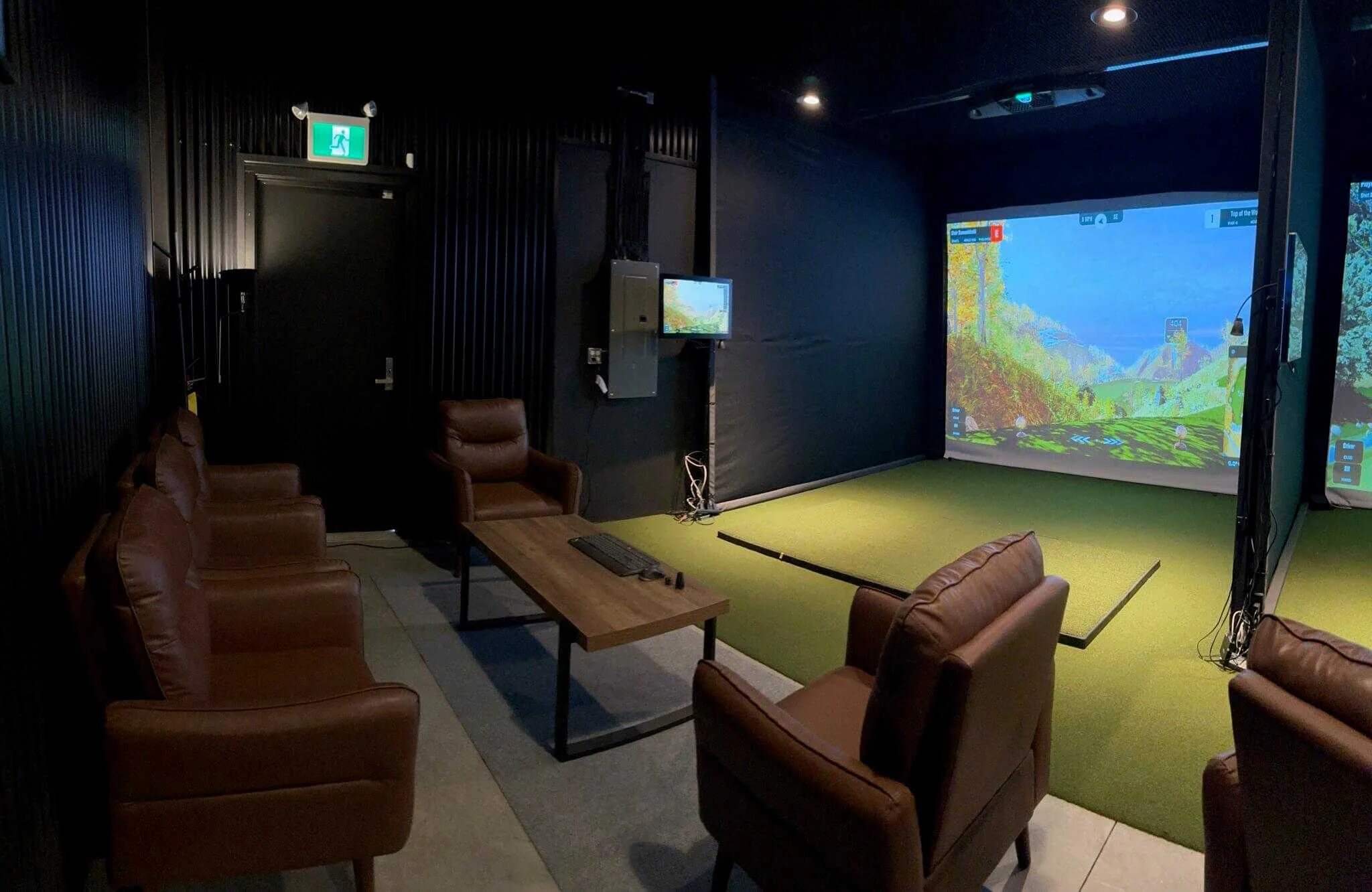 Modern indoor golf simulator lounge with leather seating and high-tech screens in Kamloops.
