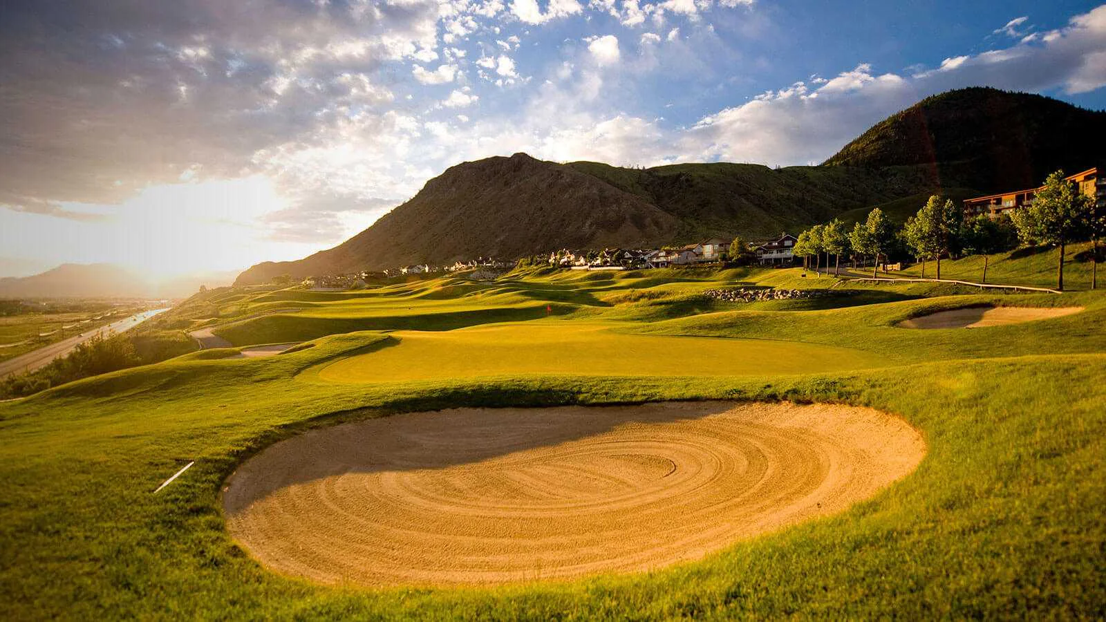 Sunset views over a sand bunker and rolling green at a Kamloops golf course.