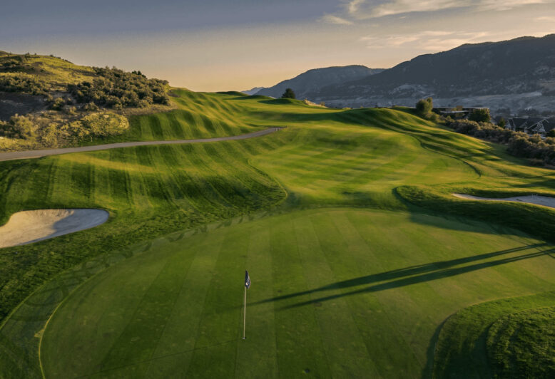 Elevated view of Bighorn Golf Kamloops green and rolling fairway contours with long evening shadows